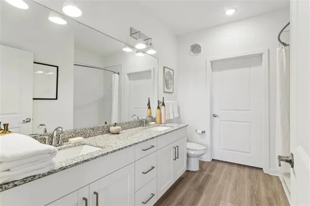 a bathroom with a granite countertop sink toilet and shower