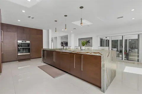 a dining room filled chandelier and kitchen view