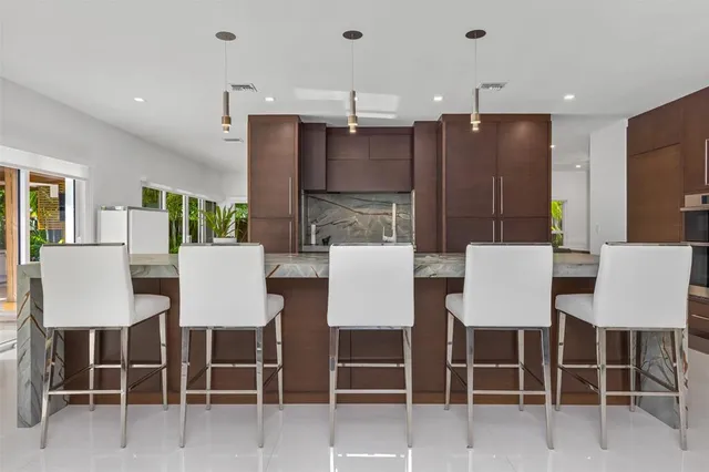 a dining room with wooden floor a chandelier a glass table and chairs