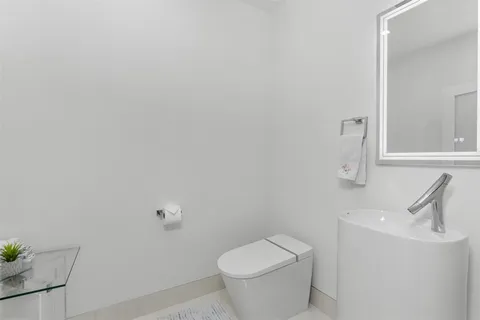 a spacious bathroom with a granite countertop sink a toilet and a large mirror