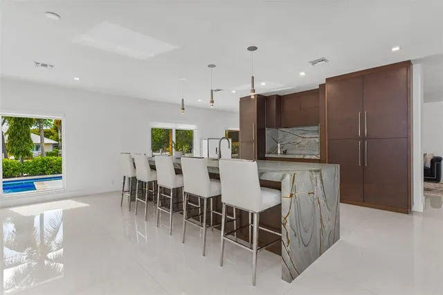 a large kitchen with stainless steel appliances kitchen island granite countertop a large counter top and couches