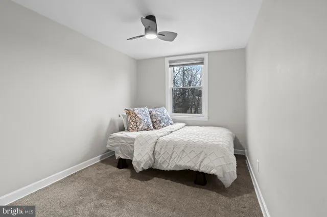 a bedroom with a bed and a ceiling fan