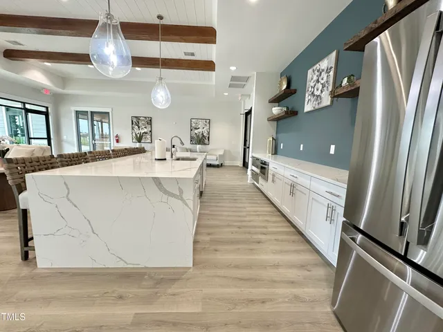 a large kitchen with stainless steel appliances a large counter top space