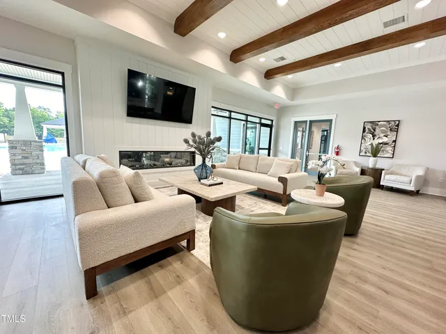 a living room with furniture wooden floor and a flat screen tv