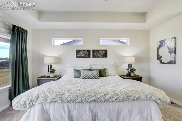 a spacious bedroom with a bed and a chandelier