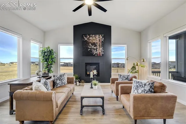 a living room with furniture large window and fireplace