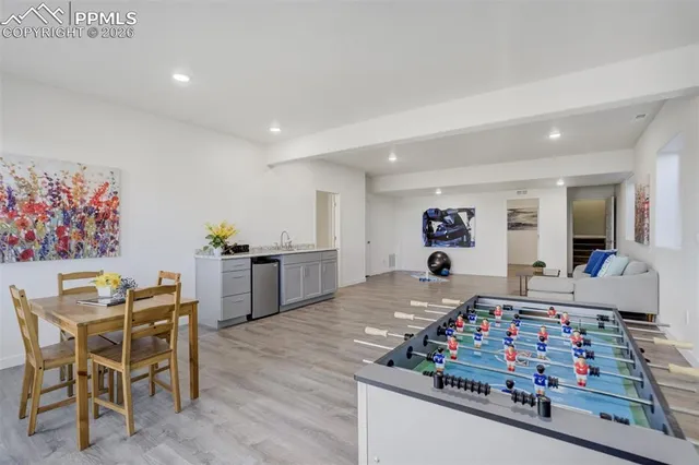 a bedroom with a bed a couch and paintings on the wall