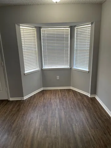 an empty room with wooden floor and a window