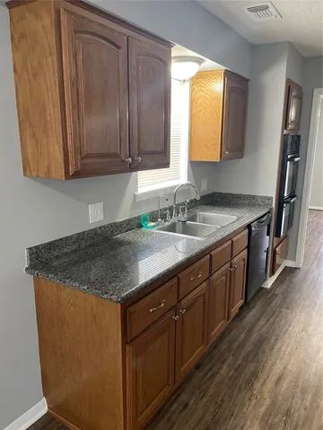 a kitchen with granite countertop a refrigerator and a sink