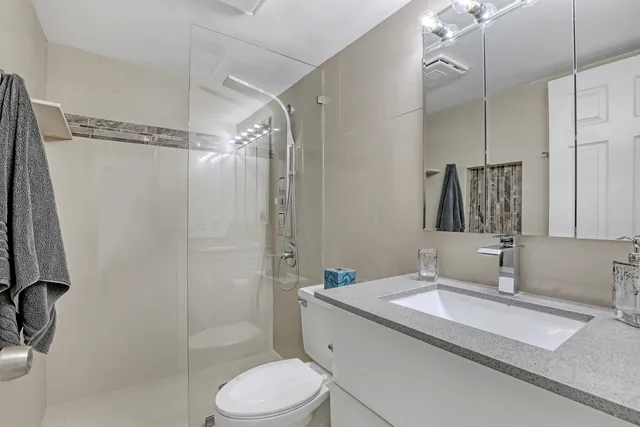 a bathroom with a granite countertop sink toilet and shower