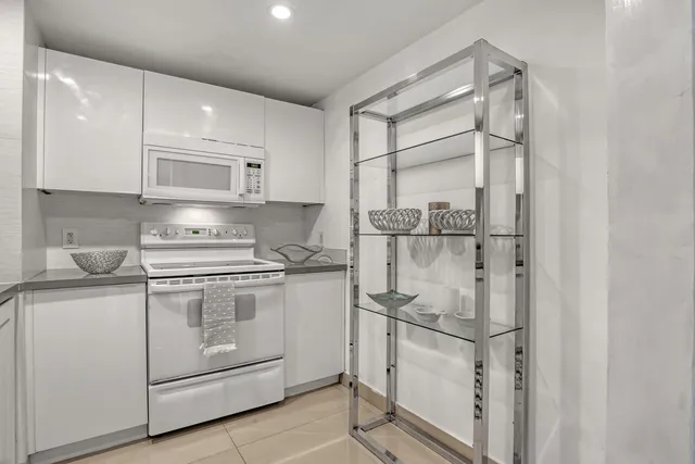 a kitchen with white cabinets and white appliances