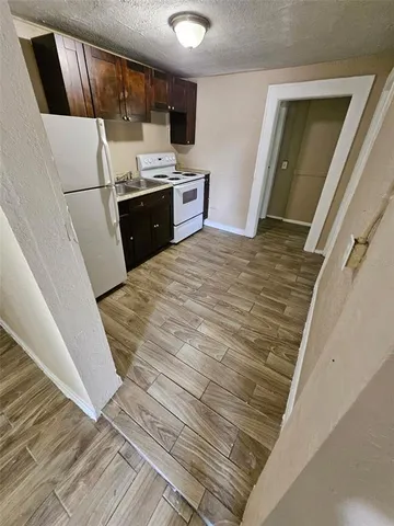 a view of kitchen with sink and refrigerator