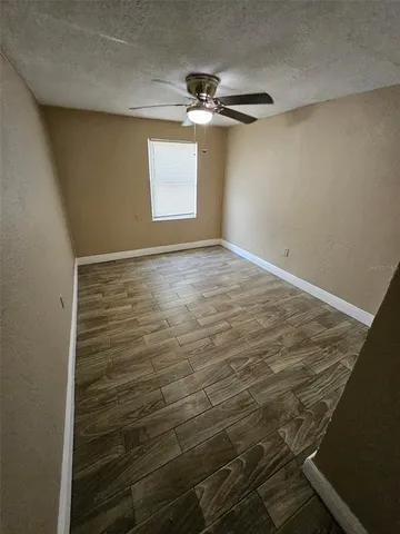 en empty room with window and wooden floor
