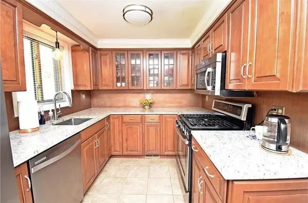 a kitchen with stainless steel appliances granite countertop a sink stove and cabinets
