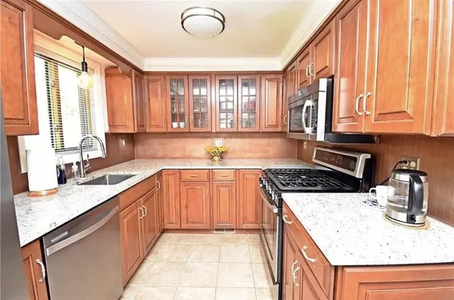 a kitchen with stainless steel appliances granite countertop a sink stove and cabinets