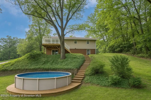 a kitchen with stainless steel appliances granite countertop white cabinets a sink a stove a microwave and wooden floors