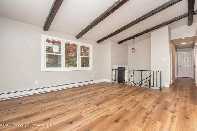 a view of an empty room and wooden floor