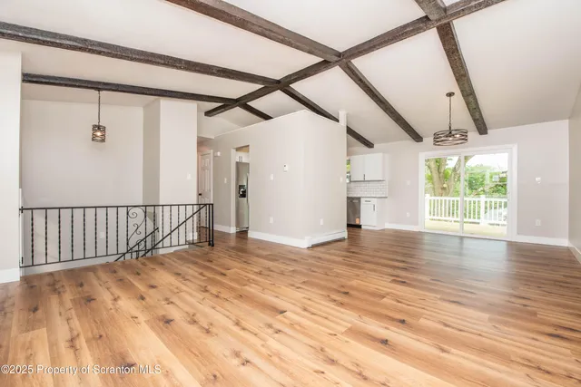a view of an empty room and wooden floor