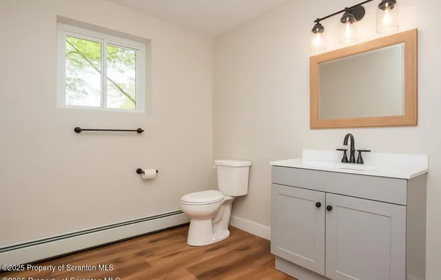 a view of empty room with wooden floor and fireplace