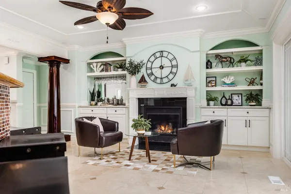 a living room with furniture a clock and a fireplace