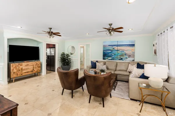 a living room with furniture a flat screen tv and a window