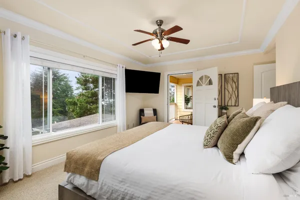 a bedroom with a bed a flat screen tv and a couch