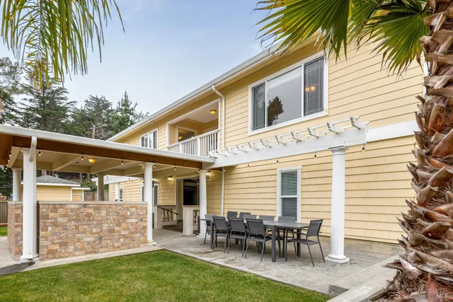 a backyard of a house with glass top table and chairs