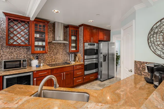 a kitchen with stainless steel appliances granite countertop a refrigerator and a stove top oven