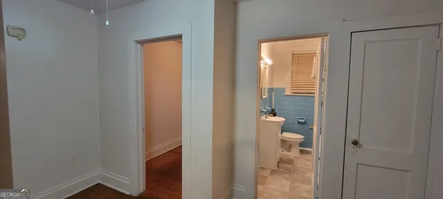 a view of a room with wooden floor chandelier and fireplace