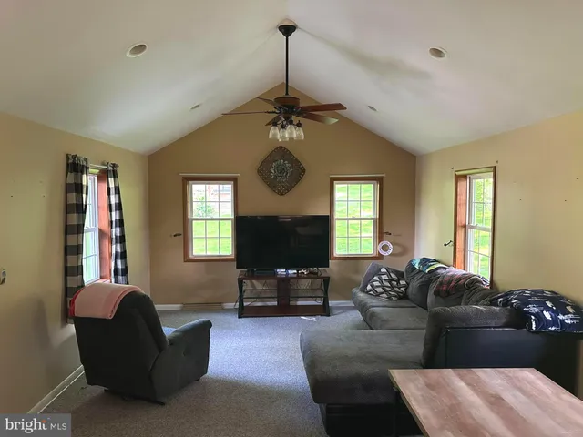 a living room with furniture a window and a flat screen tv