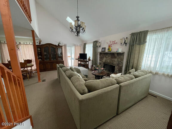 184 Skyview Road Dingmans Ferry, PA 18328 - Photo 11 of 26 a living room with furniture a fireplace and a chandelier