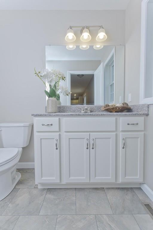 281 Gilbert Avenue Springfield, MA 01119 - Photo 15 of 31 a spacious bathroom with a granite countertop toilet a sink and a mirror