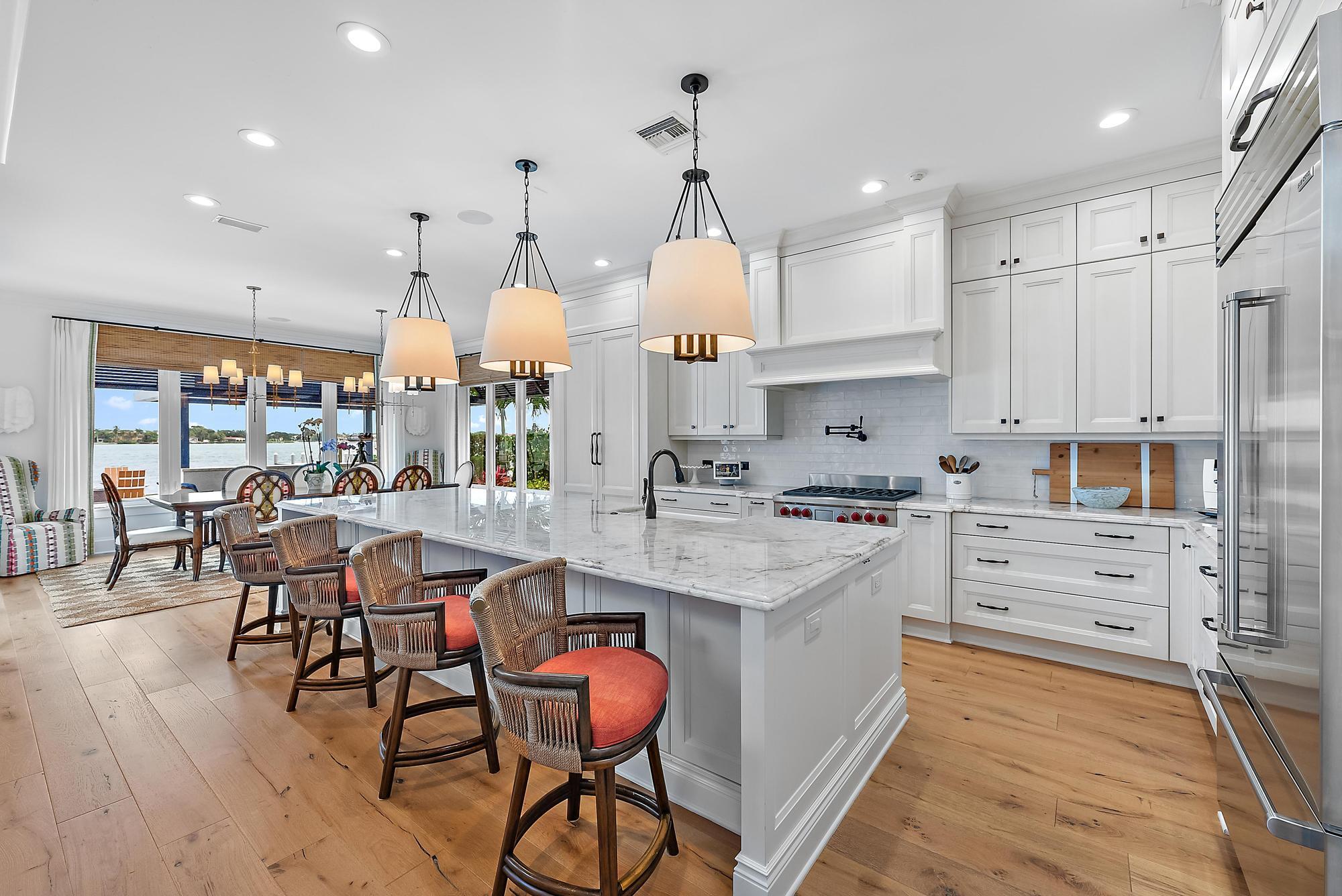 a kitchen with stainless steel appliances a dining table chairs stove and cabinets