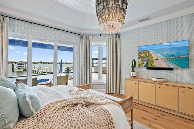 a bedroom with a large bed and a flat tv screen on dresser