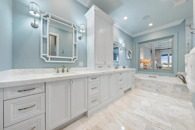 a spacious bathroom with a double vanity sink a mirror a bathtub and