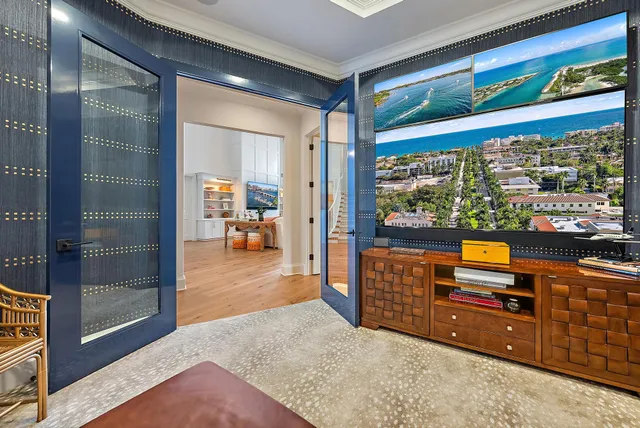 a living room with furniture a flat screen tv and floor to ceiling window