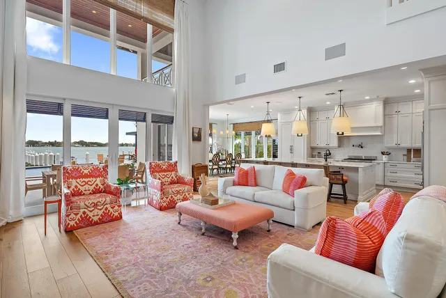 a living room with furniture kitchen view and a large window