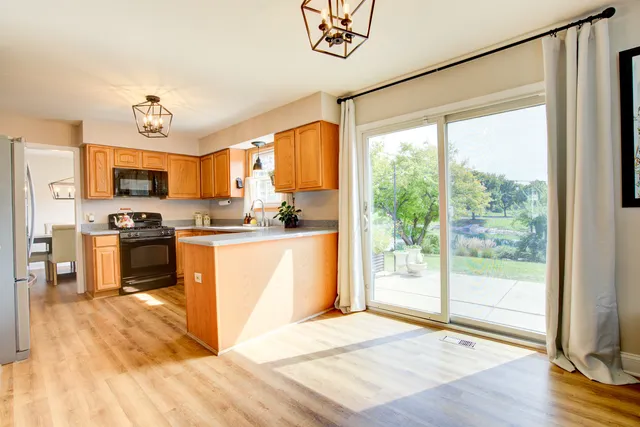 a kitchen with granite countertop a stove a sink and a refrigerator