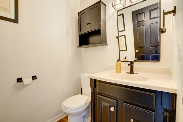 a bathroom with a sink a toilet and mirror