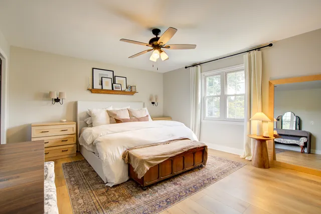 a spacious bedroom with a bed and wooden floor