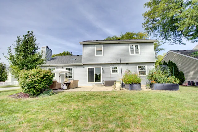 a front view of a house with a yard and potted plants