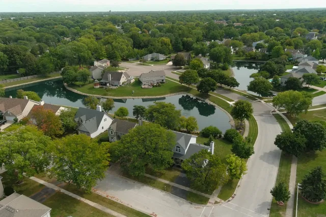 an aerial view of a house with a yard and lake view