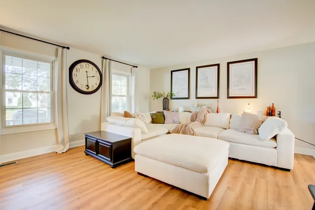 a living room with furniture a fireplace and a large window