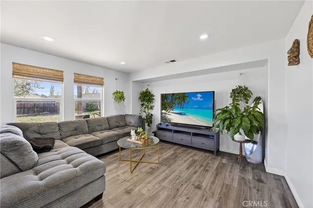 a living room with furniture a potted plant and a large window