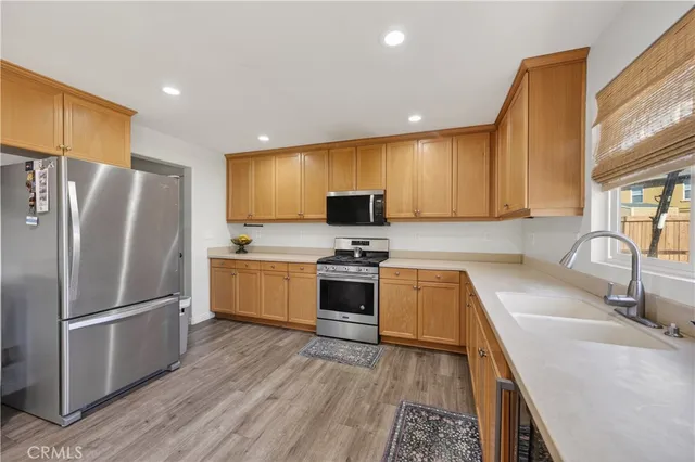 a kitchen with granite countertop a refrigerator stove and sink