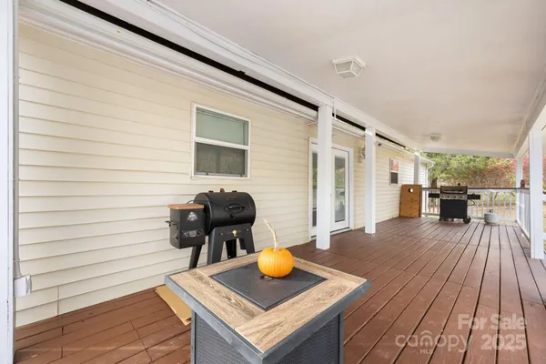 a view of a wooden table and chairs in patio of the house