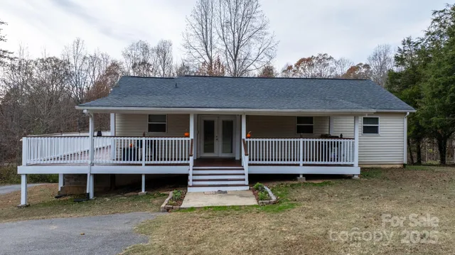 a view of a house with a yard and wooden deck
