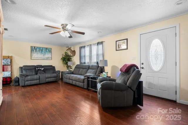 a living room with furniture a ceiling fan and a wooden floor