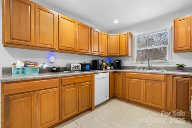 a kitchen with stainless steel appliances granite countertop a sink cabinets and a window