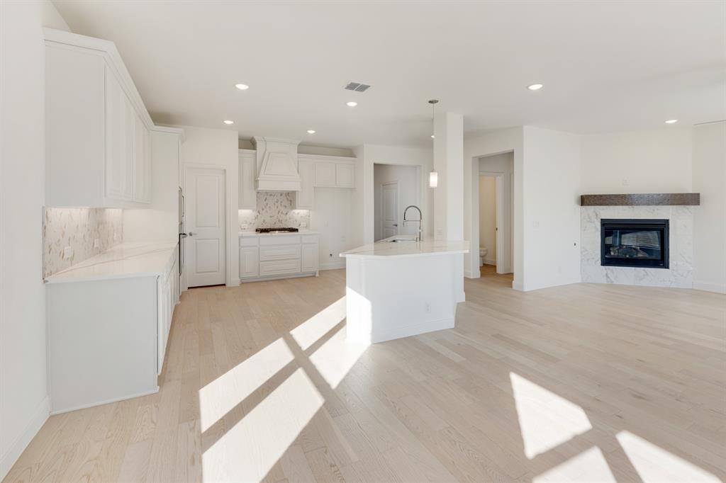 7308 Iris Road Aubrey, TX 76227 - Photo 12 of 40 a living room with stainless steel appliances furniture a rug and a kitchen view